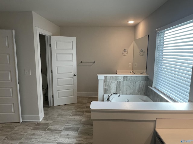 bathroom featuring a bathing tub, vanity, and toilet