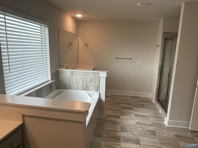 bathroom featuring shower with separate bathtub and vanity