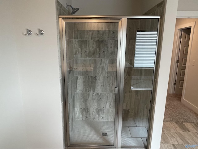 bathroom featuring a shower with door