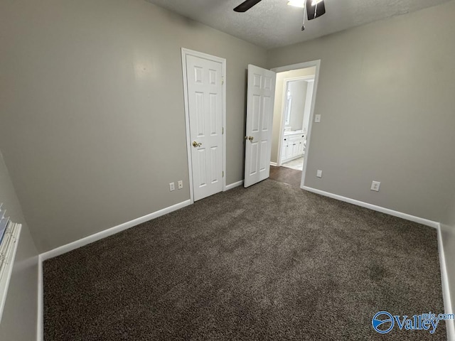 unfurnished bedroom featuring baseboards, dark colored carpet, and ceiling fan