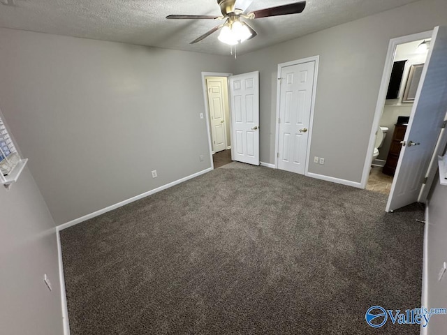unfurnished bedroom featuring a ceiling fan, a textured ceiling, ensuite bathroom, baseboards, and dark colored carpet
