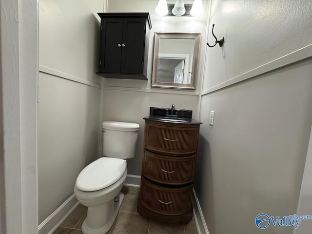 bathroom with vanity, toilet, baseboards, and tile patterned floors
