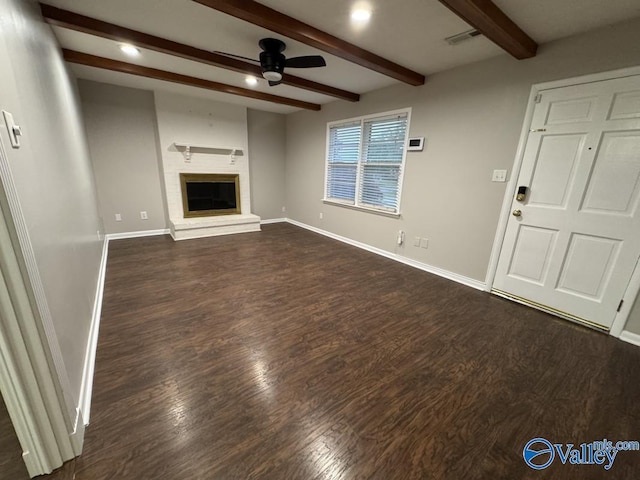 unfurnished living room featuring a fireplace, baseboards, beamed ceiling, ceiling fan, and dark wood-style floors