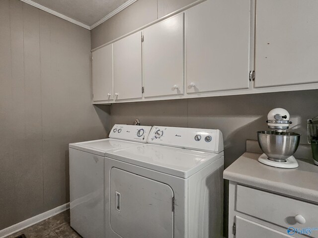 laundry room with cabinet space, washing machine and dryer, crown molding, and baseboards