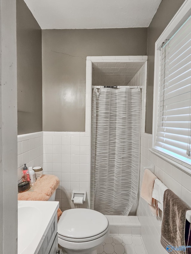 full bath with curtained shower, toilet, and tile walls