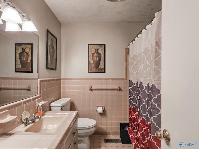 full bath featuring vanity, a shower with shower curtain, toilet, and visible vents