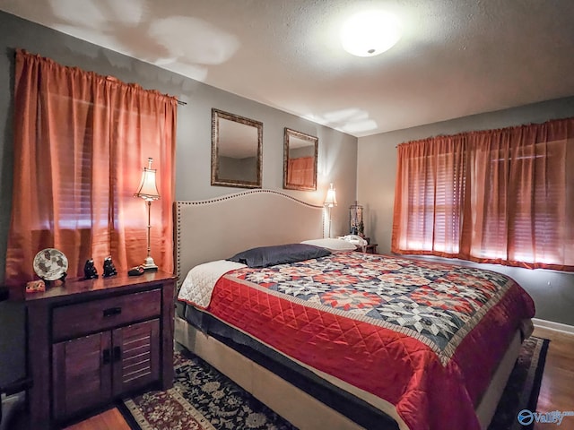 bedroom with a textured ceiling and wood finished floors