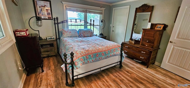 bedroom with hardwood / wood-style flooring and crown molding