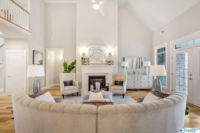 living room with french doors, high vaulted ceiling, and light hardwood / wood-style flooring