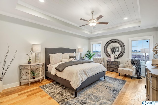 bedroom with wood ceiling, ceiling fan, hardwood / wood-style floors, a tray ceiling, and ornamental molding