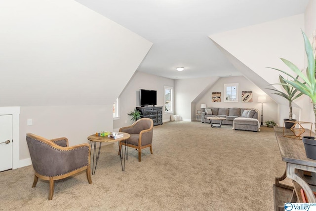 living area featuring light colored carpet and vaulted ceiling