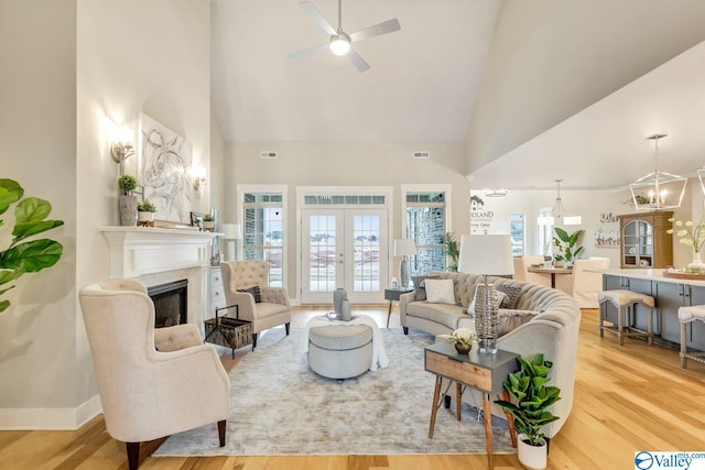 living room featuring french doors, a high ceiling, and light hardwood / wood-style flooring