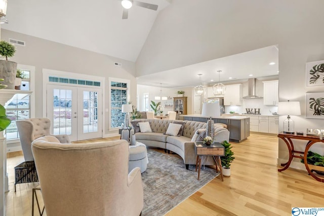 living room featuring french doors, ceiling fan, high vaulted ceiling, and light wood-type flooring