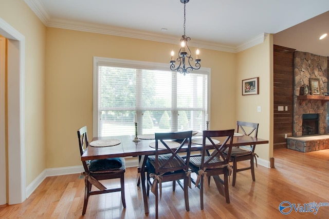 2701 Arbor Oak Dr SE, Owens Cross Roads, AL 35763 - dining room featuring light wood-style flooring, a chandelier, ornamental molding, baseboards, and a fireplace