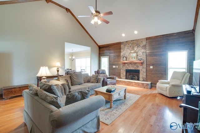 2701 Arbor Oak Dr SE, Owens Cross Roads, AL 35763 - living area featuring wooden walls, high vaulted ceiling, a ceiling fan, crown molding, and a stone fireplace
