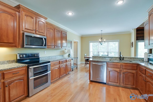 2701 Arbor Oak Dr SE, Owens Cross Roads, AL 35763 - kitchen featuring stainless steel appliances, a sink, light wood-style flooring, light stone counters, and a chandelier
