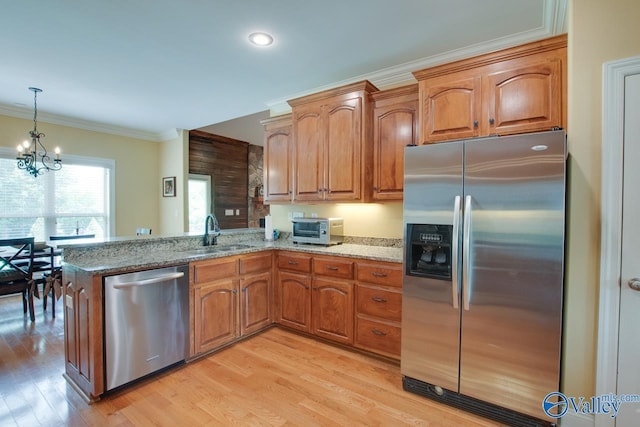 2701 Arbor Oak Dr SE, Owens Cross Roads, AL 35763 - kitchen with stainless steel appliances, a sink, a chandelier, light stone countertops, and light wood-type flooring