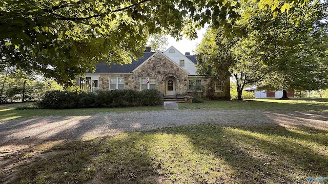 view of front facade featuring stone siding and a front lawn