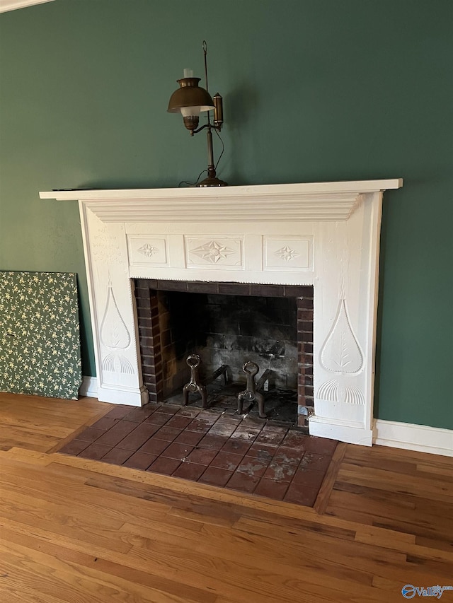 room details with a fireplace, wood finished floors, and baseboards