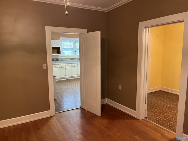 unfurnished room with dark wood-style floors, baseboards, and crown molding