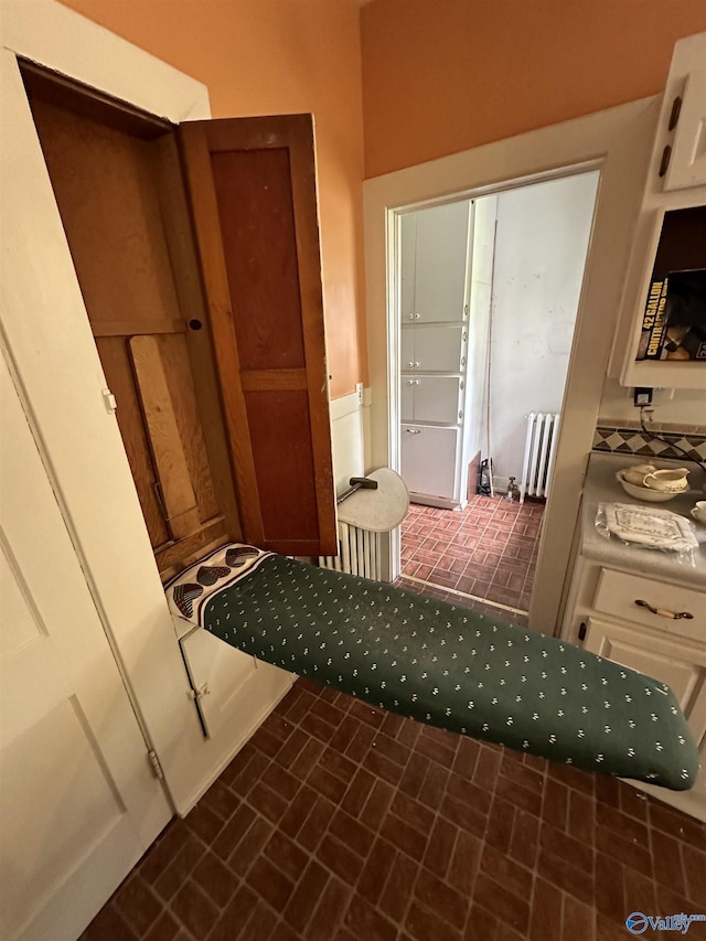 interior space with brick floor and radiator