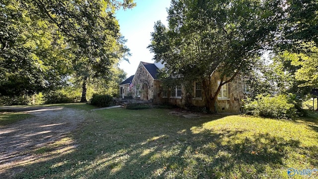 view of property exterior featuring stone siding and a yard