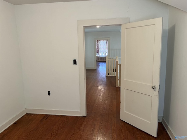 hall featuring radiator, baseboards, dark wood finished floors, and an upstairs landing