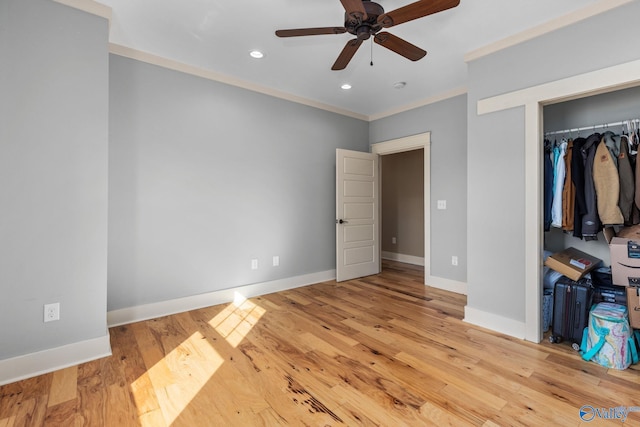 unfurnished bedroom with a closet, baseboards, ornamental molding, wood finished floors, and recessed lighting