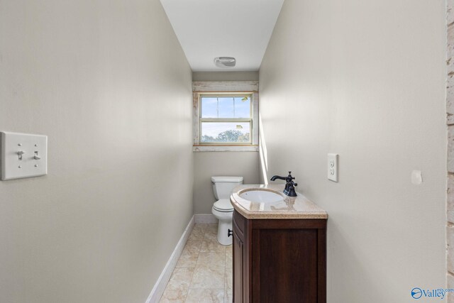 half bathroom with toilet, vanity, and baseboards