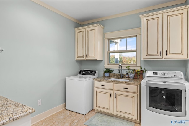 laundry room with a sink, cabinet space, washer / dryer, and baseboards