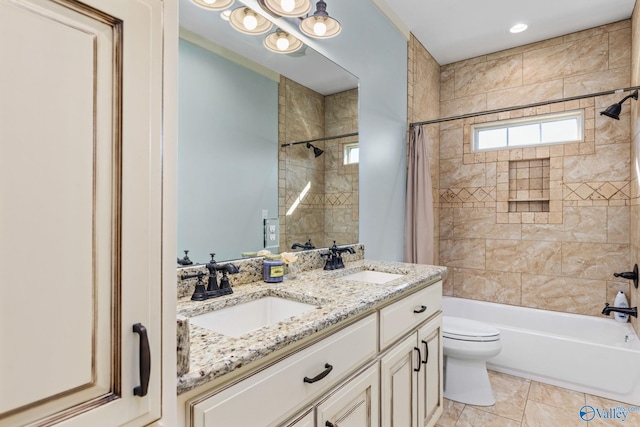 full bathroom featuring toilet, a sink, double vanity, and shower / bath combo