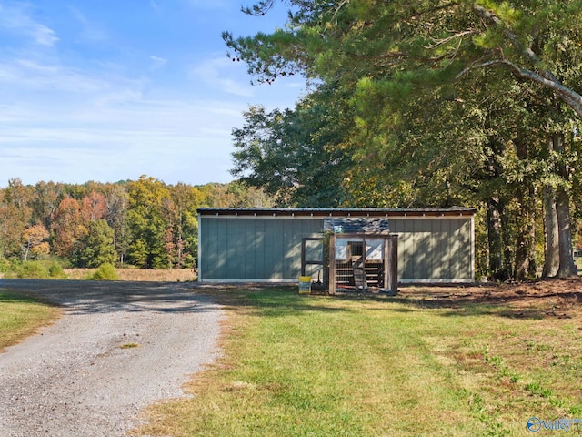 view of pole building with gravel driveway and a yard