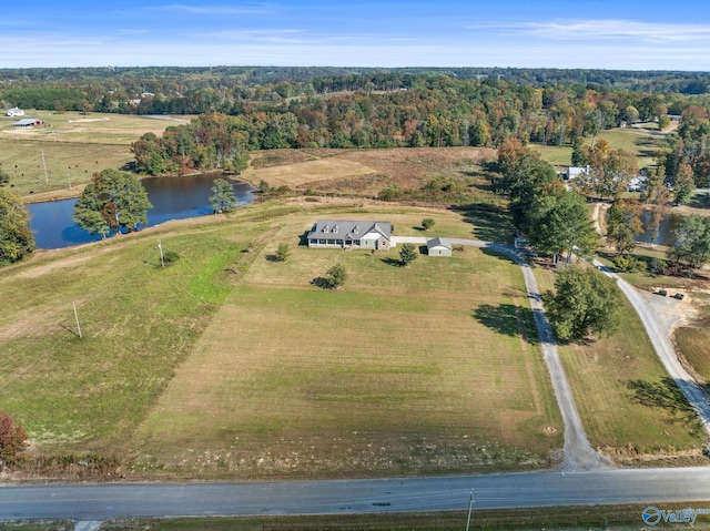 drone / aerial view featuring a wooded view and a water view