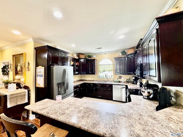 kitchen with ornamental molding, dark brown cabinets, a kitchen breakfast bar, kitchen peninsula, and appliances with stainless steel finishes