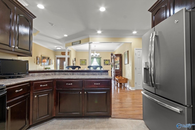 kitchen featuring recessed lighting, a peninsula, crown molding, and stainless steel fridge