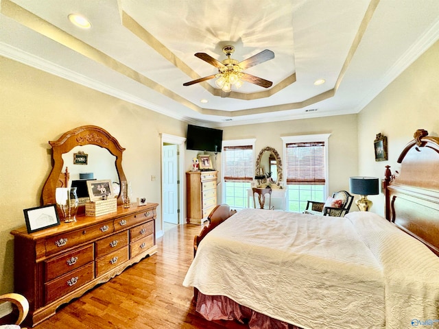 bedroom featuring ornamental molding, a raised ceiling, hardwood / wood-style flooring, and ceiling fan