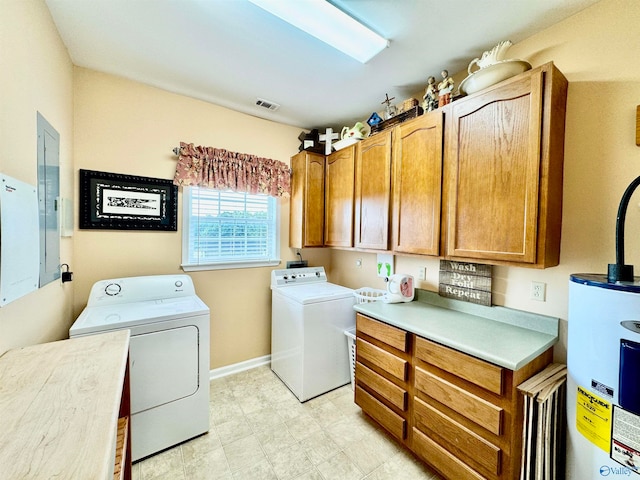 laundry room with washing machine and clothes dryer, cabinets, and water heater