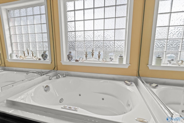 bathroom featuring a wealth of natural light and a jetted tub