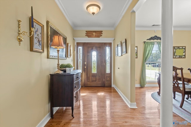 entryway with light wood-style floors, baseboards, ornamental molding, and visible vents