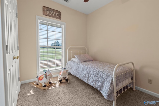 carpeted bedroom featuring visible vents, baseboards, and a ceiling fan