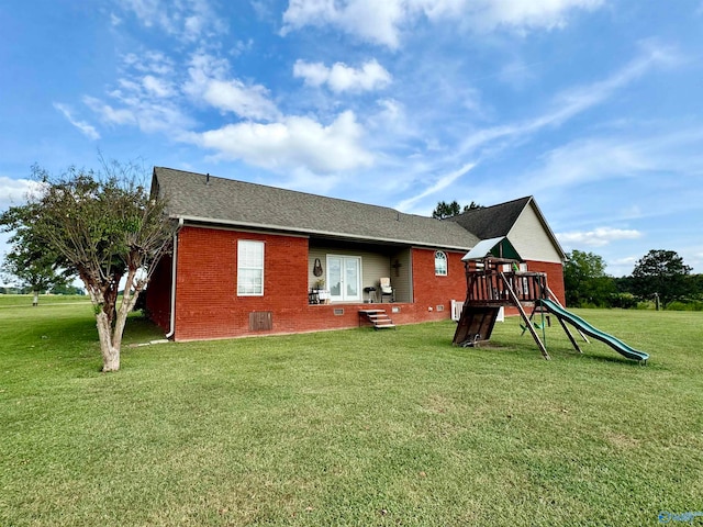 rear view of house featuring a yard and a playground