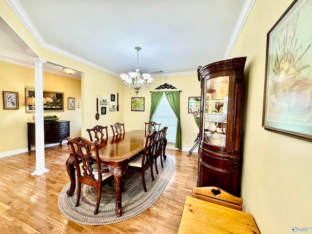 dining room featuring crown molding, light hardwood / wood-style flooring, and decorative columns