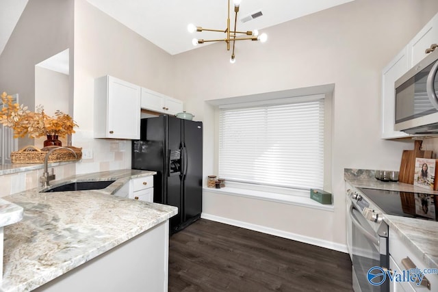 kitchen featuring light stone counters, stainless steel appliances, a sink, visible vents, and white cabinetry