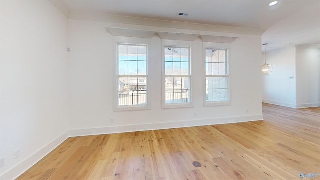 empty room featuring baseboards, a ceiling fan, and light wood-style floors