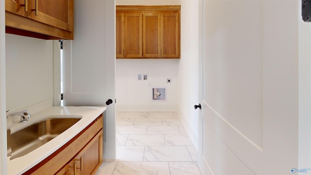 clothes washing area featuring hookup for a washing machine, electric dryer hookup, cabinet space, marble finish floor, and a sink