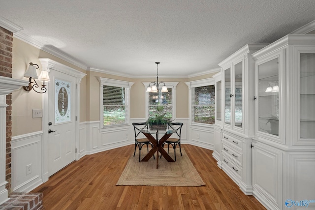 7925 Smoke Rise Rd SE, Huntsville, AL 35802 - dining area featuring a chandelier, wood finished floors, a textured ceiling, wainscoting, and ornamental molding