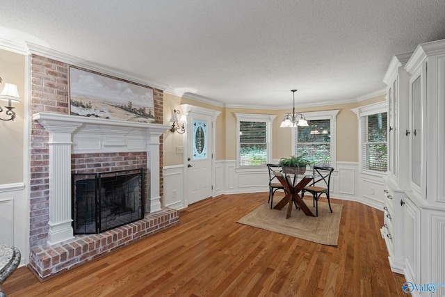 7925 Smoke Rise Rd SE, Huntsville, AL 35802 - dining area featuring a textured ceiling, wood finished floors, a fireplace, a wainscoted wall, and a decorative wall