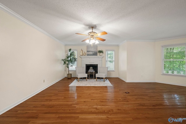 7925 Smoke Rise Rd SE, Huntsville, AL 35802 - unfurnished living room featuring ceiling fan, a textured ceiling, wood finished floors, ornamental molding, and a fireplace