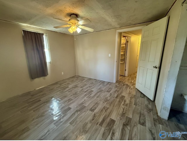 empty room with ceiling fan and light wood-type flooring