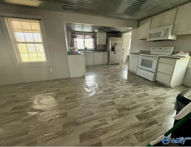 kitchen featuring white cabinetry, white appliances, sink, and light hardwood / wood-style floors